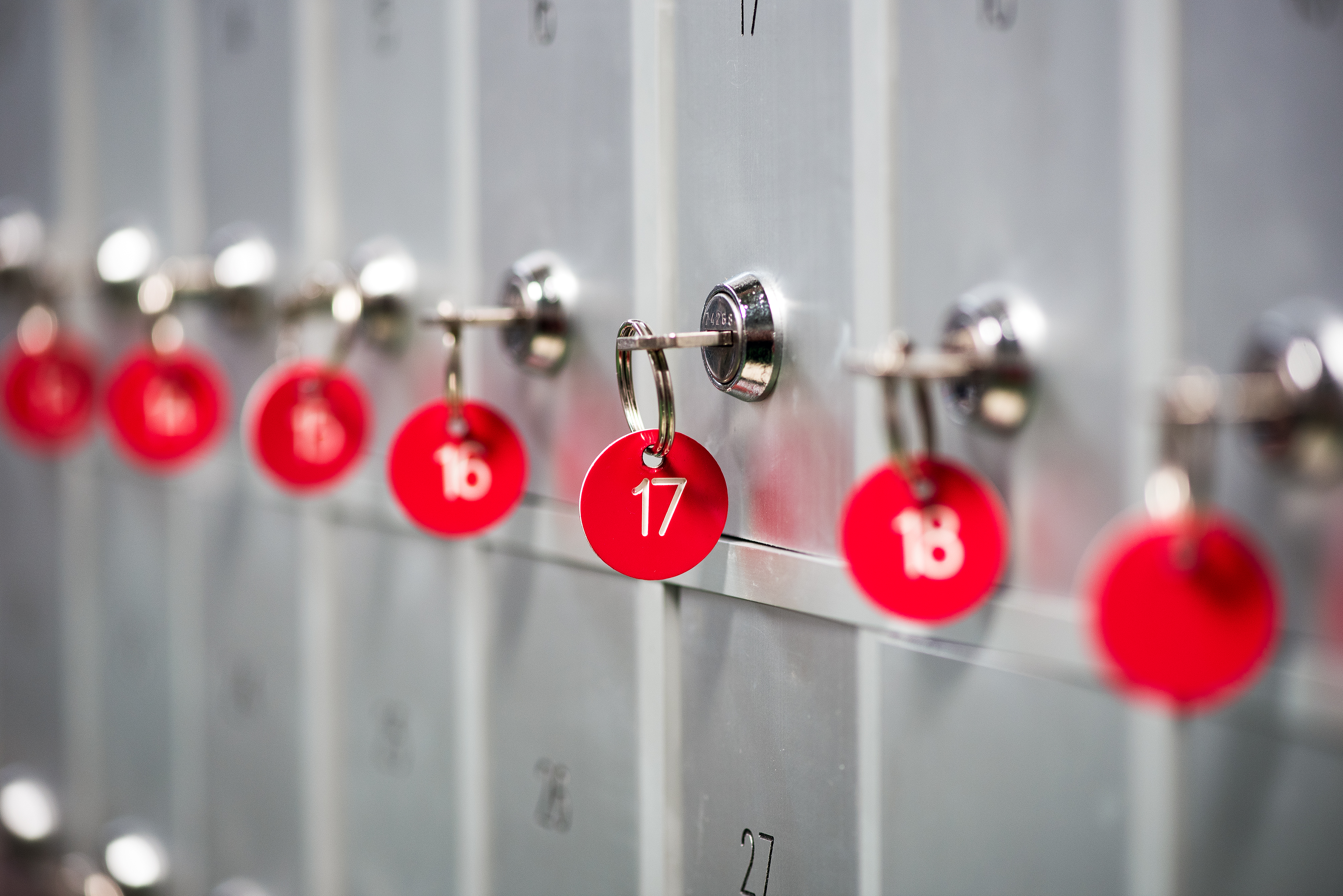 A close-up of grey metal lockers with red key numbers
