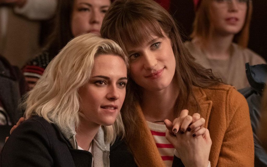 Kristen Stewart and Mackenzie Davis holding hands in Happiest Season