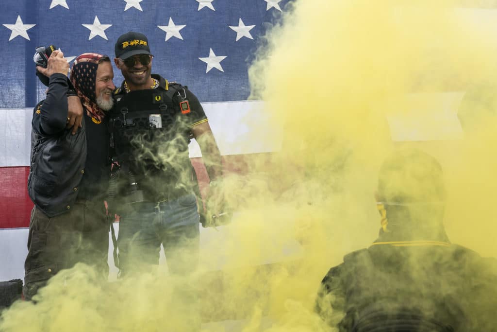 Proud Boy leader Enrique Tarrio (R) hugs a fellow member