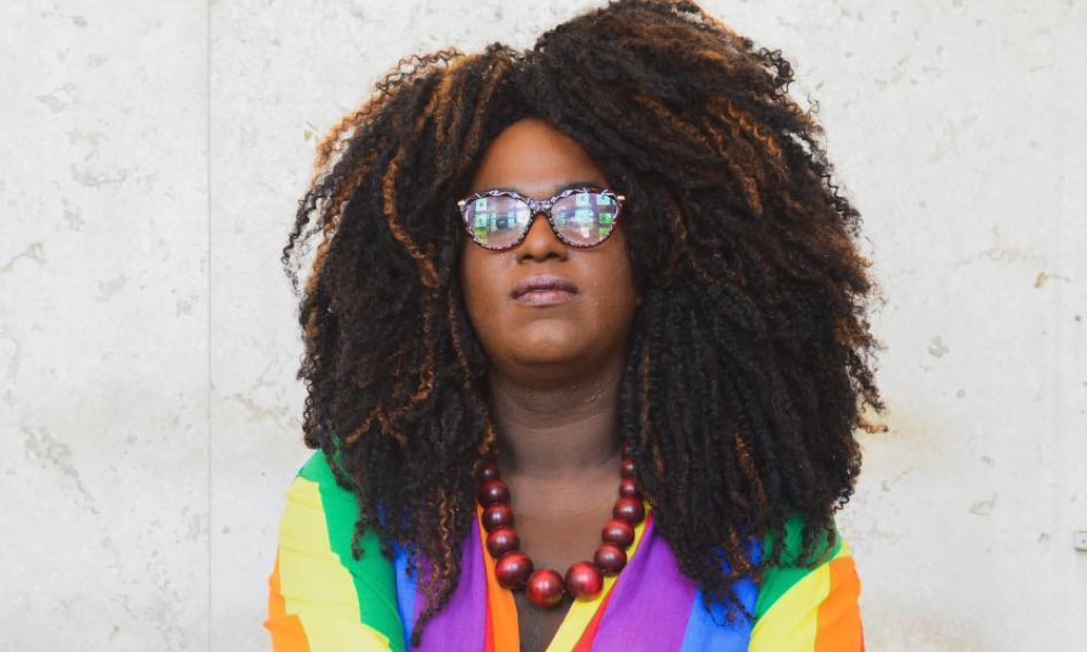 Benny Briolly poses in a rainbow top