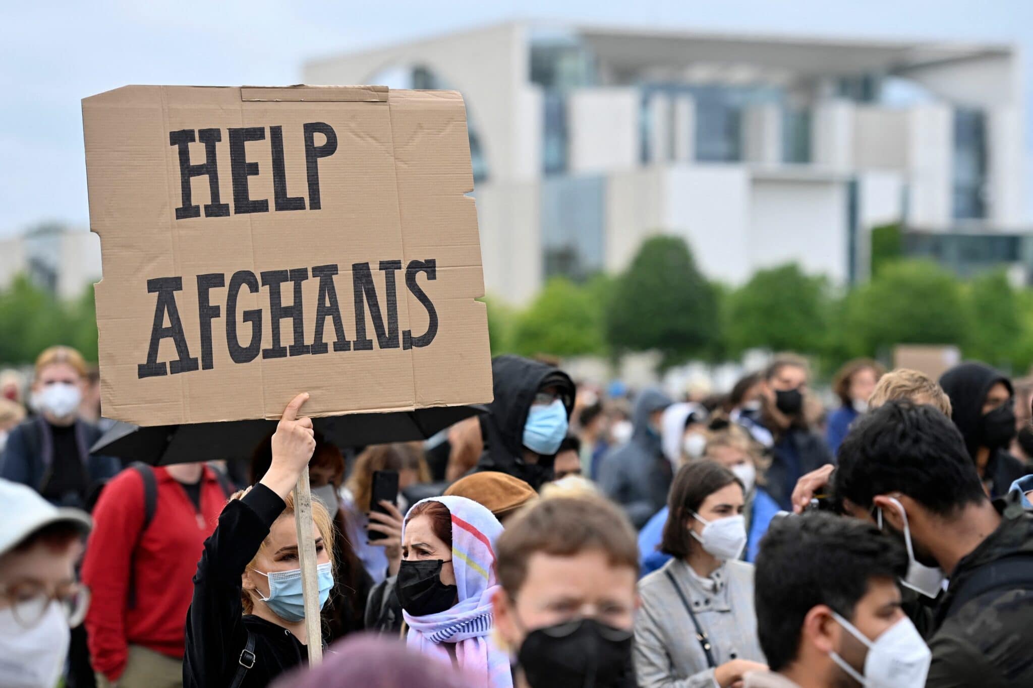 A participant holds up a placard reading 