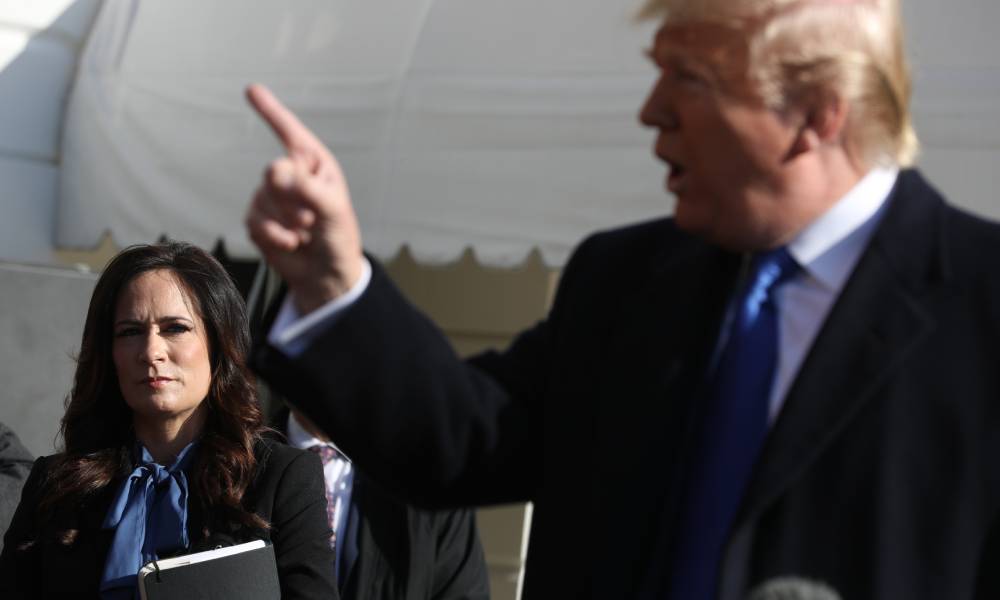 Former White House press secretary Stephanie Grisham listens to president Donald Trump talk to reporters