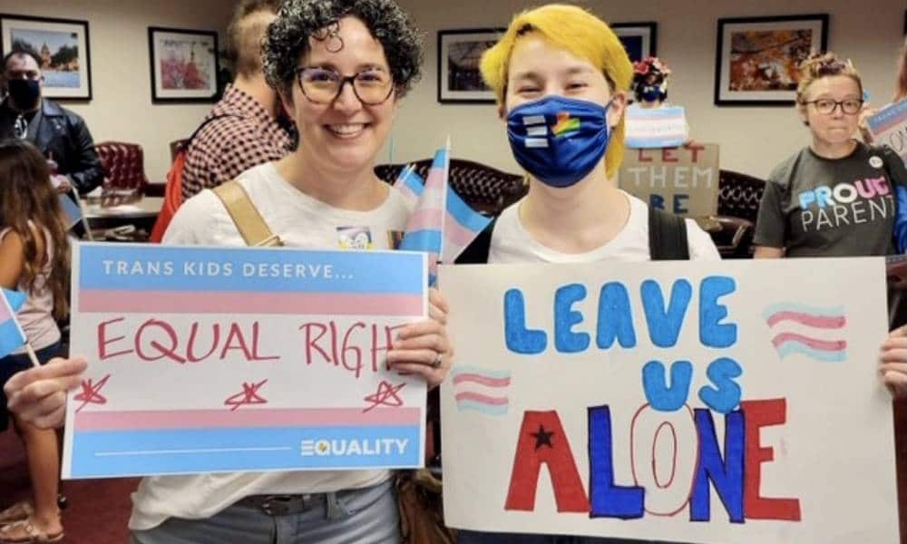 Mandy Giles and Indigo attend a trans rights protest in Texas. Mandy holds up a sign calling for equal rights for trans people while Indigo holds up a right that reads 