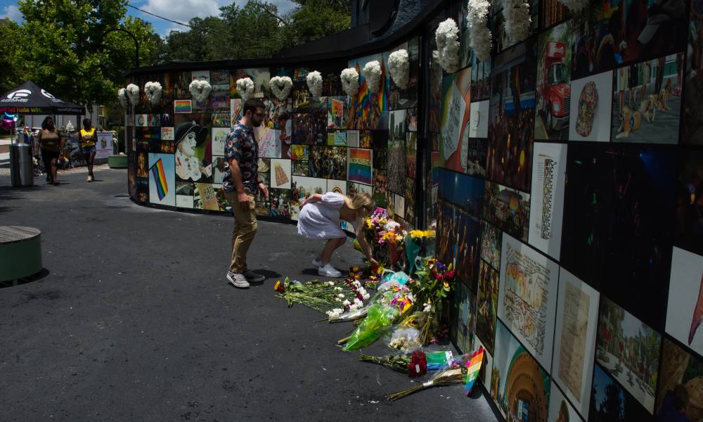 A person leaves flowers at the interim Pulse memorial