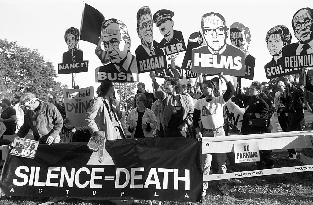 Members of AIDS activist group ACT UP hold up signs of George W. Bush, Ronald Reagan, Nancy Reagan, Jesse Helms and other with the word &quot;Guilty&quot; stamped on their foreheads on October 11, 1988