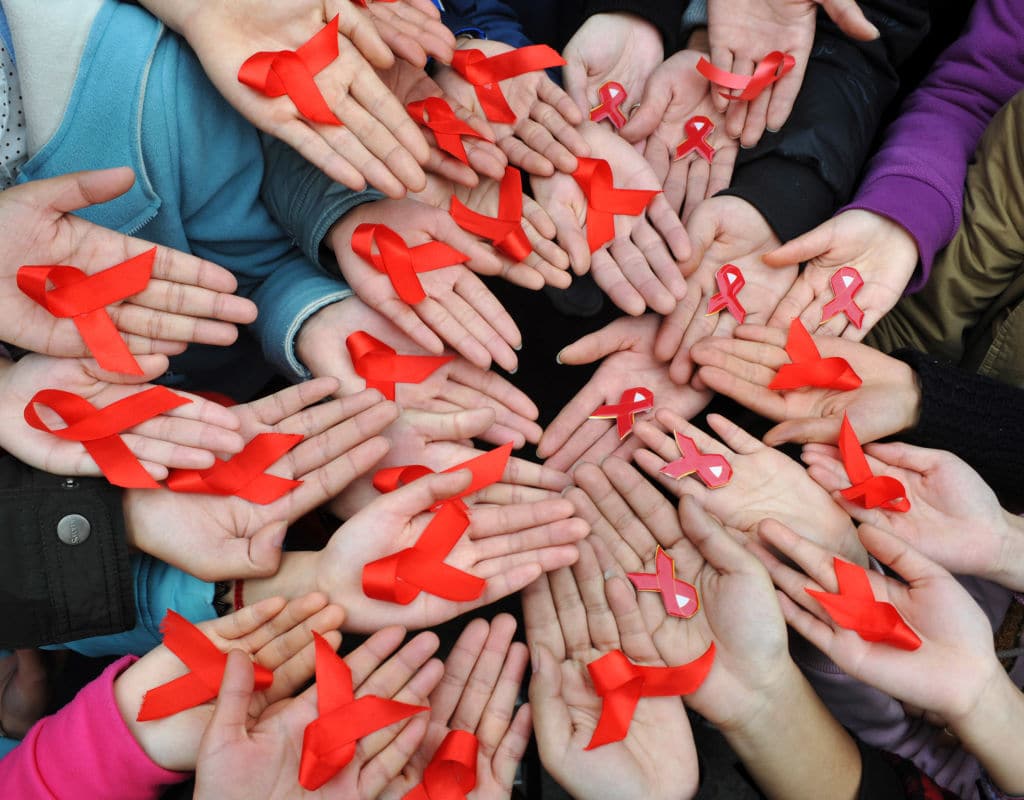 University students display red ribbons during an event to promote the awareness of AIDS at the Sichuan University on World AIDS Day 2009.