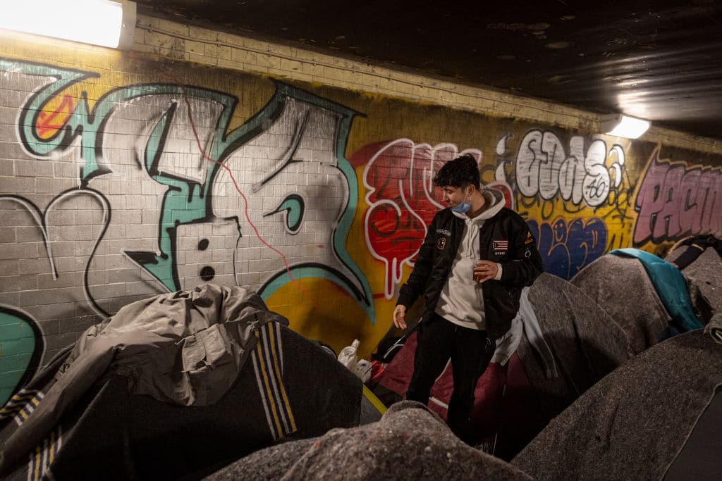 An Afghan man who fled the Taliban takeover of Kabul speaks to a friend at a temporary shelter for migrants and refugees, on November 30, 2021.