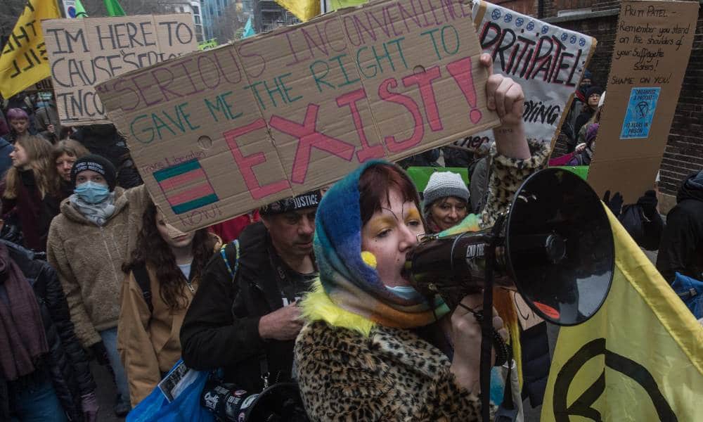 Protestors hold up a placard that reads 