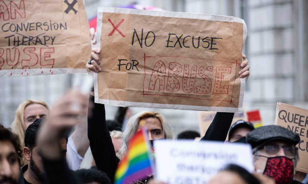 A protester holds a placard saying &quot;No excuse for abuse&quot; during a demonstration against conversion therapy outside UK Cabinet office