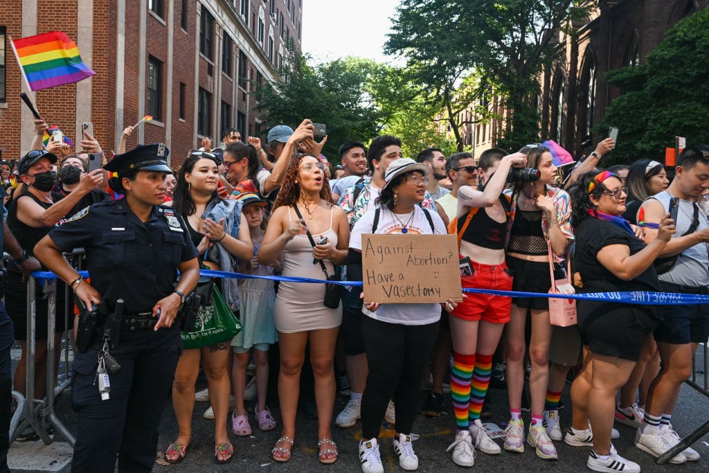 A person holds a &quot;against abortion, have a vasectomy&quot; sign in the New York City Pride Parade.