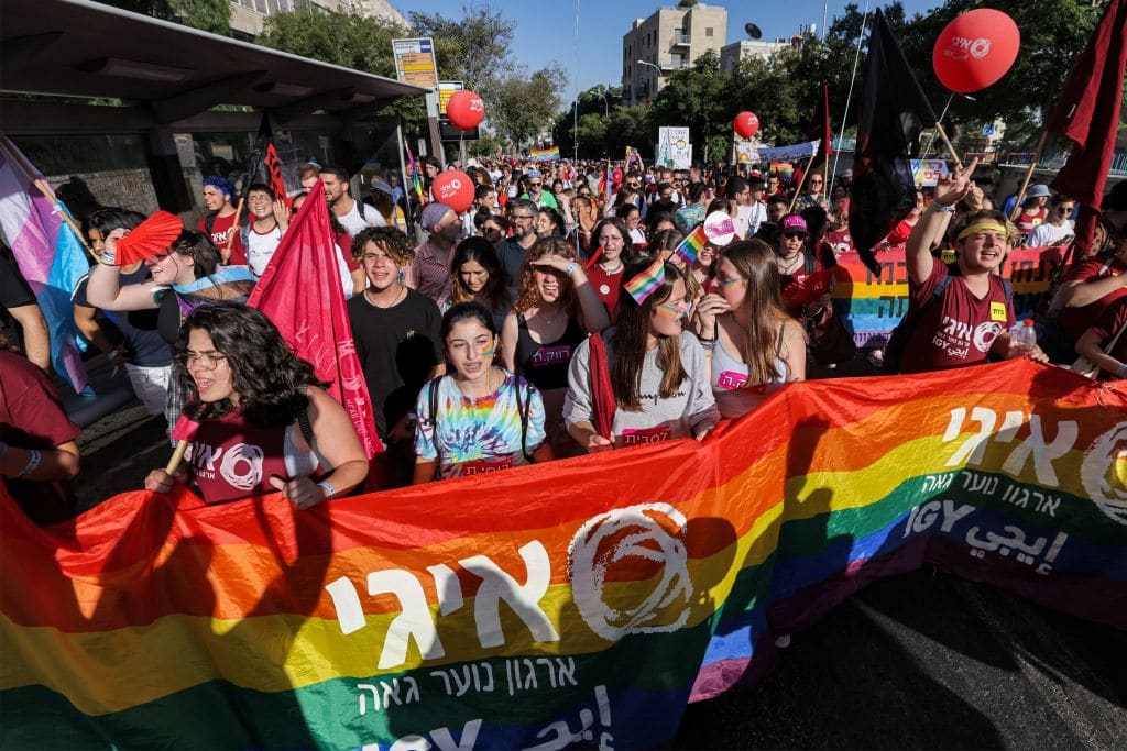 Participants march with a giant rainbow banner showing the logo of the &quot;Israel Gay Youth&quot; (IGY) NGO
