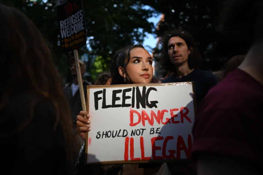 A woman holds a placard saying 