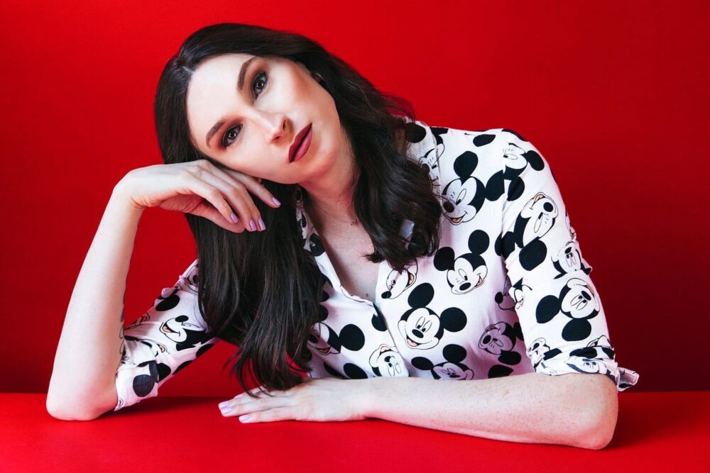 Juno Dawson tilting her head with a red background.