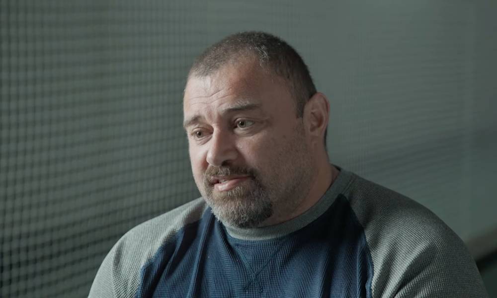 Former New Zealand cricketer Heath Davis wears a dark blue shirt with grey sleeves as he sits down for an interview