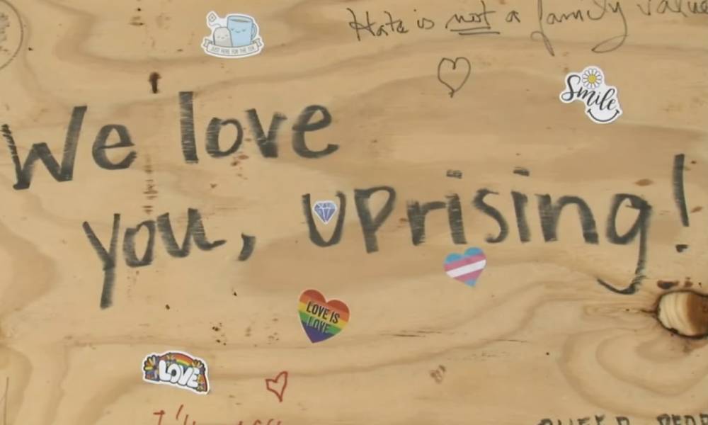 A board on the window of UpRising Bakery and Café reads 