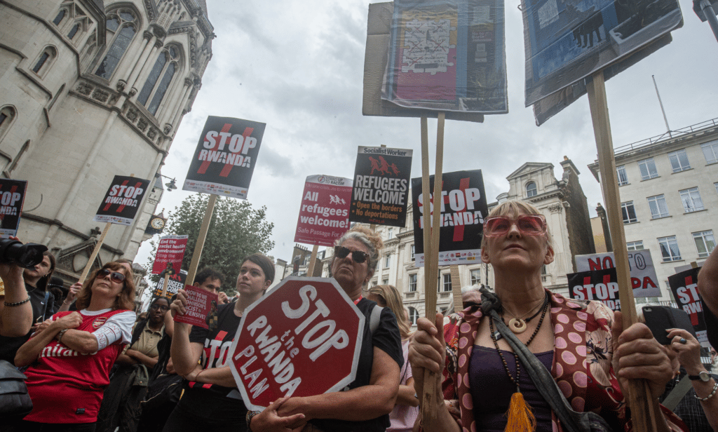 People gather outside the High Court to protest against Priti Patel