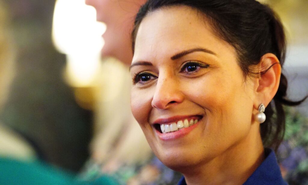 Priti Patel smiles at the camera