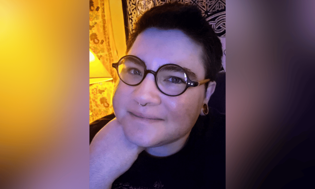 A person poses with their hand below their chin