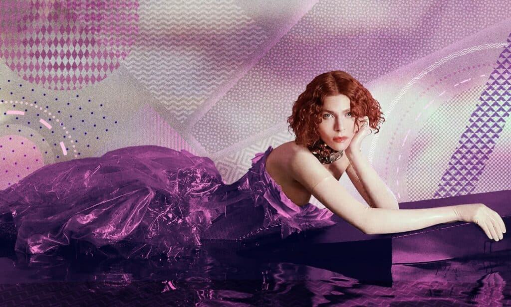 Sophie Xeon, better known as SOPHIE, poses in a purple dress.