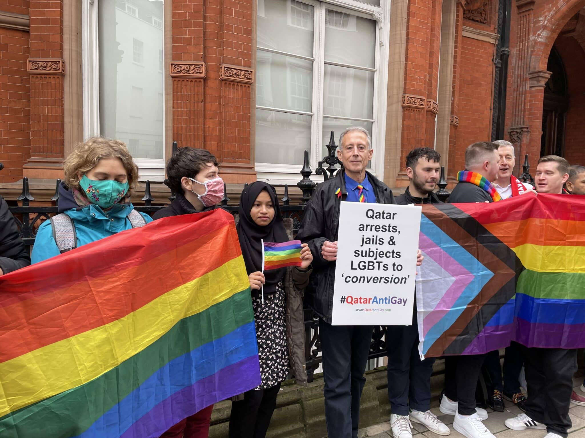 Peter Tatchell holds up a placard that reads 