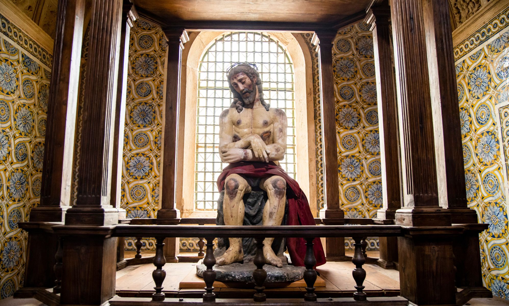 A statue of the Jesus Christ sat on a pedestal in a church-like setting