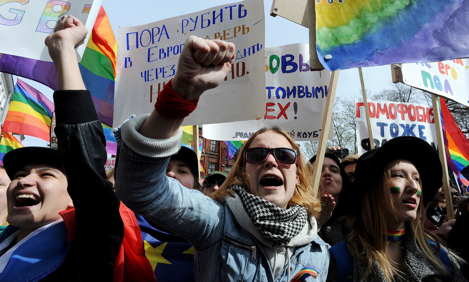 A photo of LGBTQ+ activists holding placards taking part in a May Day rally in Saint Petersburg, Russia to protest against anti-LGBTQ+ legislation including a 