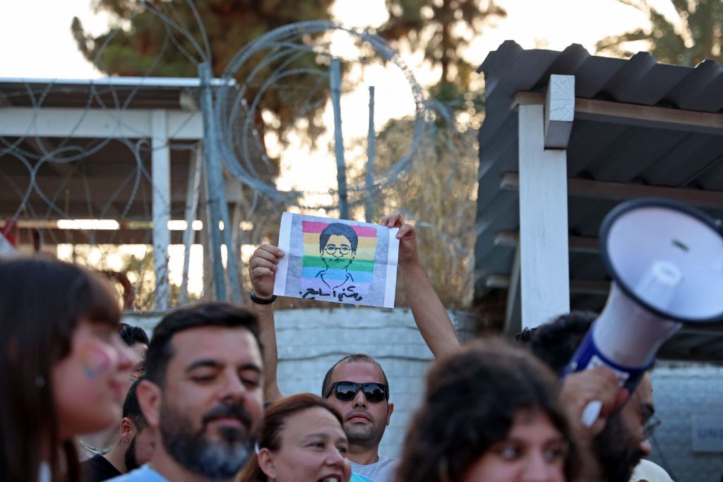 A participant holds up a silhouette picture depicting the late Egyptian LGBTQI activist Sarah Hegazi coloured with the rainbow flag during Cyprus