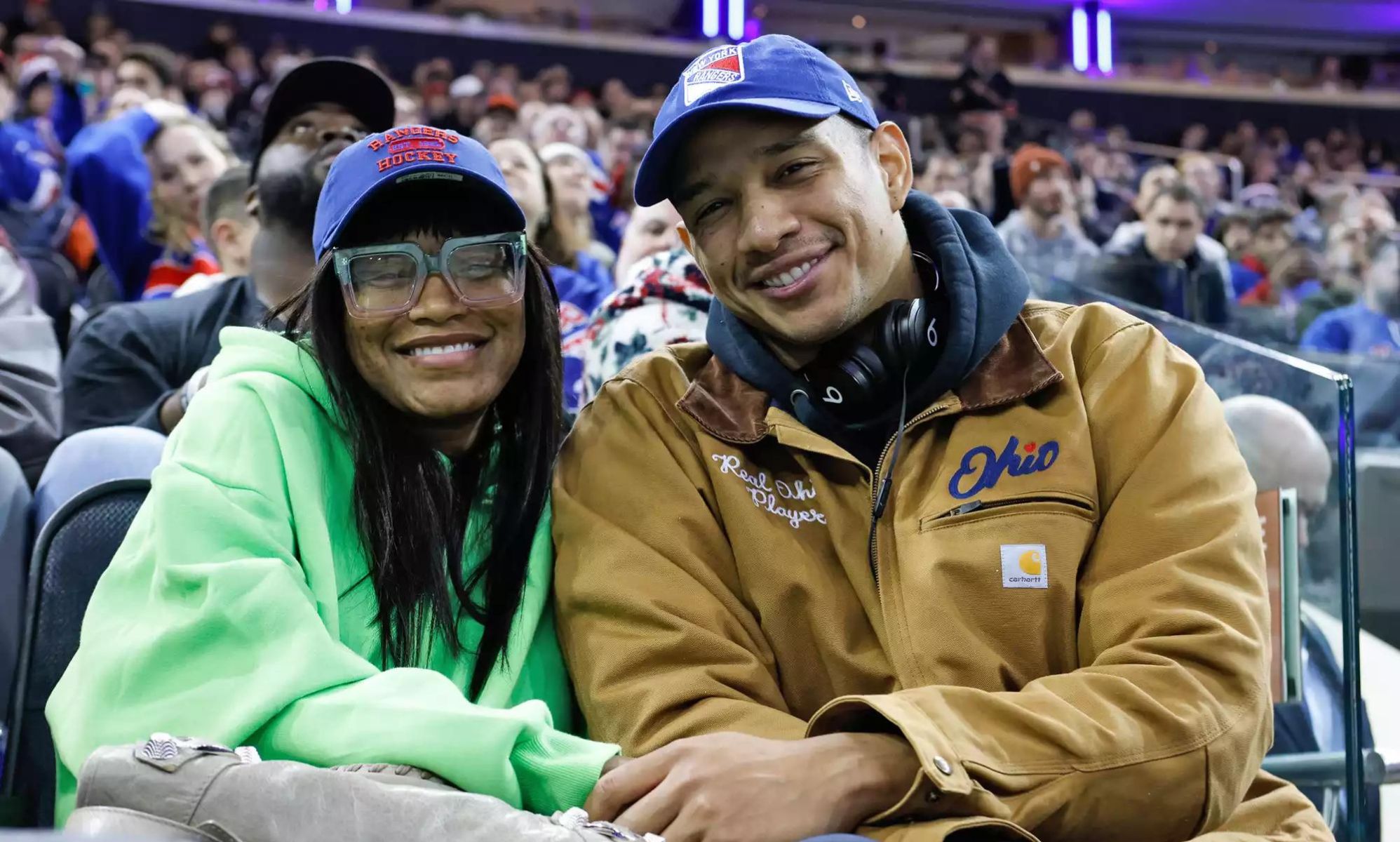 Keke Palmer and Darius Jackson sitting court side in a sports stadium