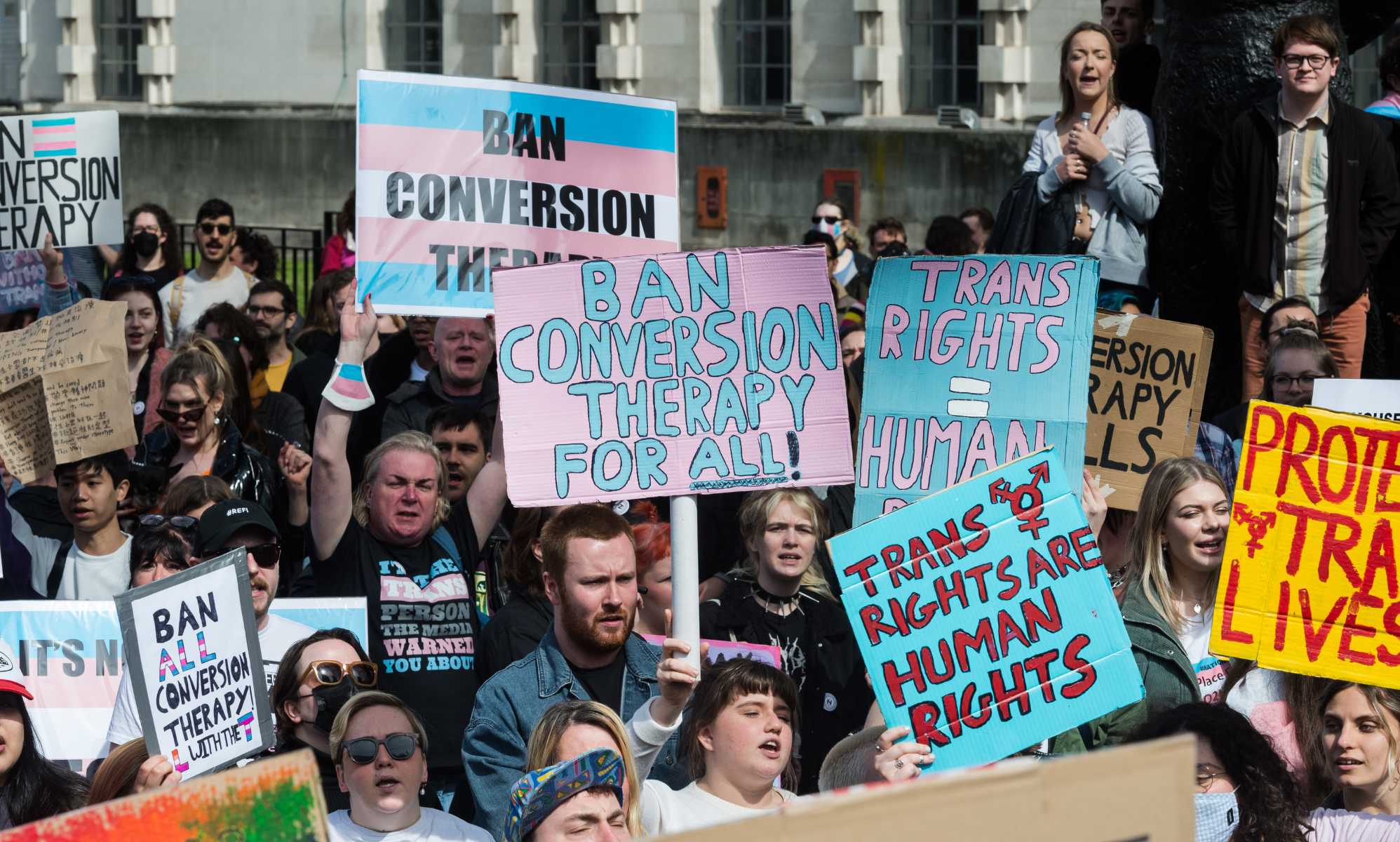 LGBTQ+ protesters holding signs that read 