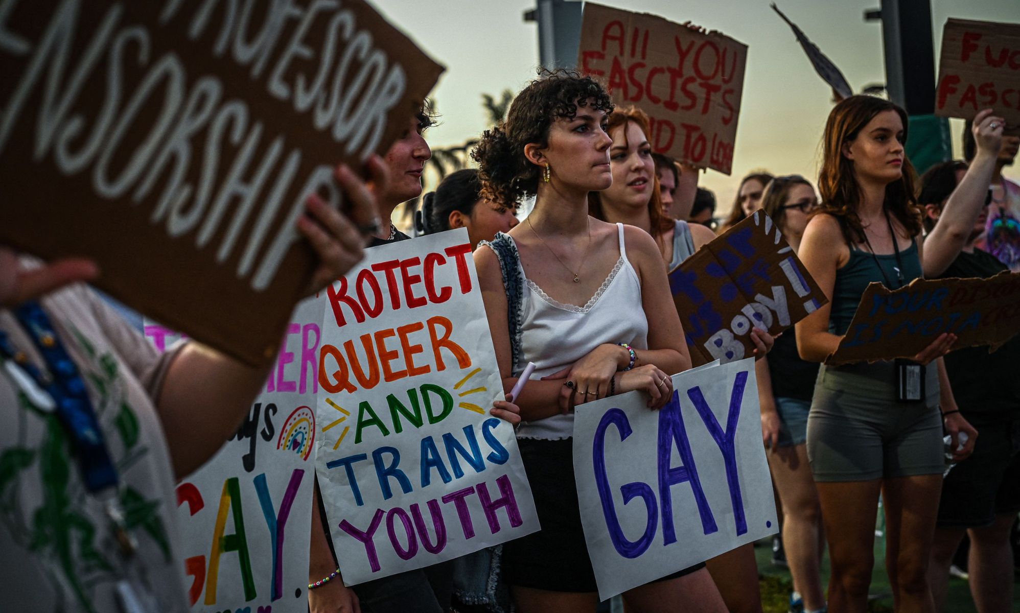 LGBTQ+ rights advocates gather around in protest of Ron DeSantis and the 