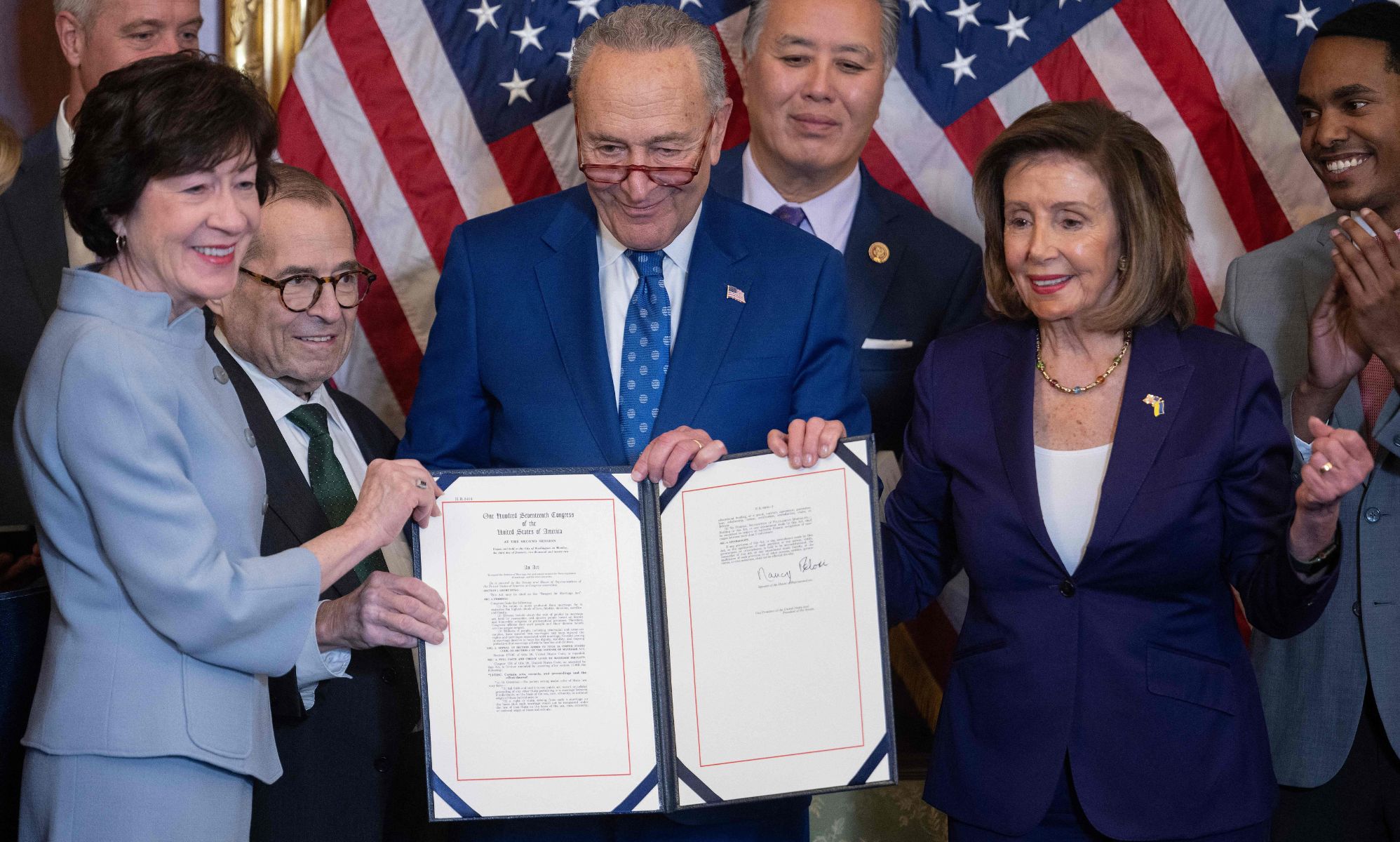 Members of Congress gather around to celebrate the Respect for Marriage Act