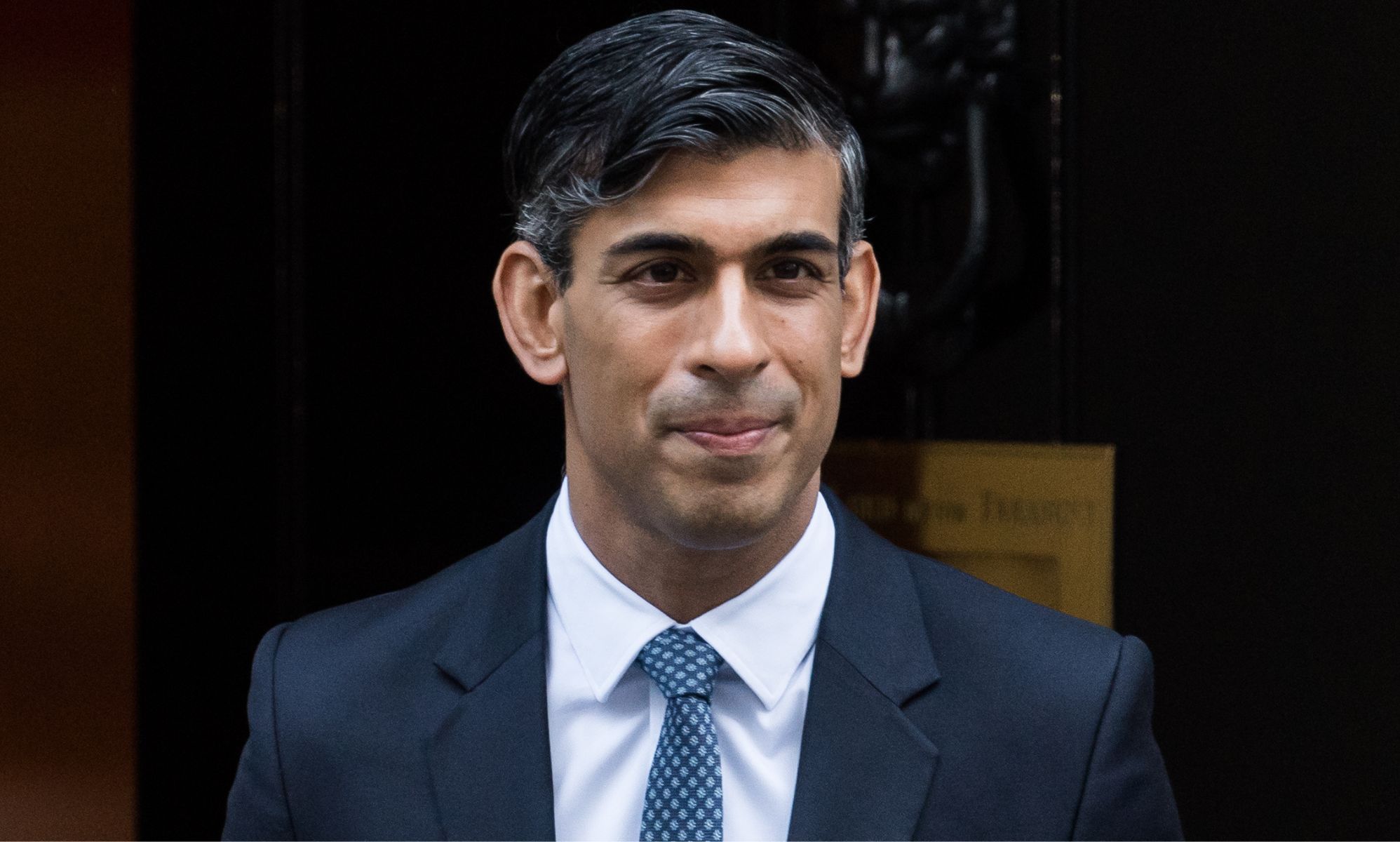 Rishi Sunak leaving Number 10, smiling.
