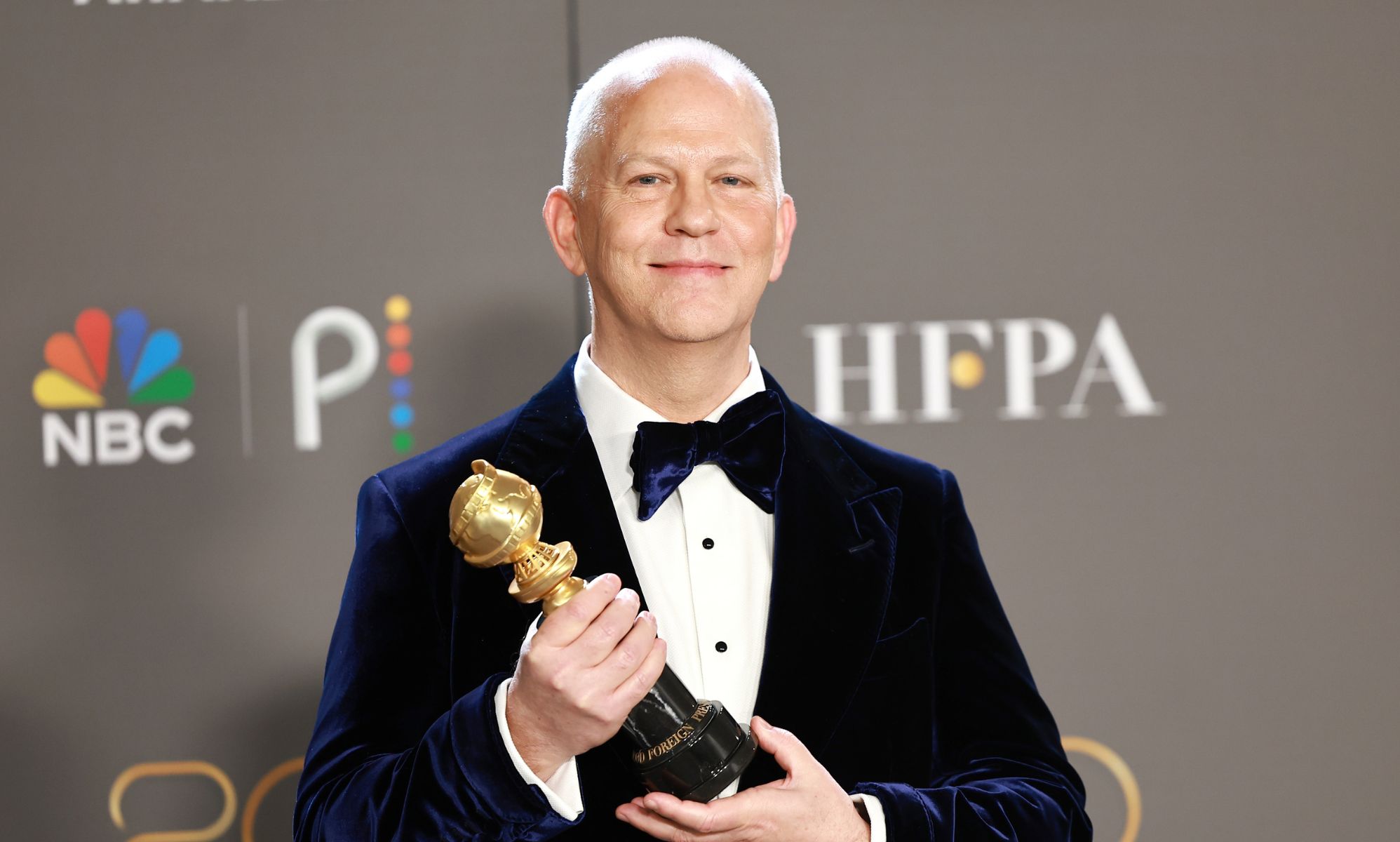 Ryan Murphy holding his Golden Globe Carol Burnett Award
