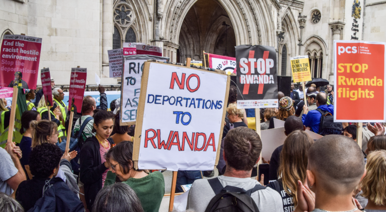 A protester holds a placard which states &quot;No deportations to Rwanda&quot; during a demonstration to halt deportations of refugees to Rwanda