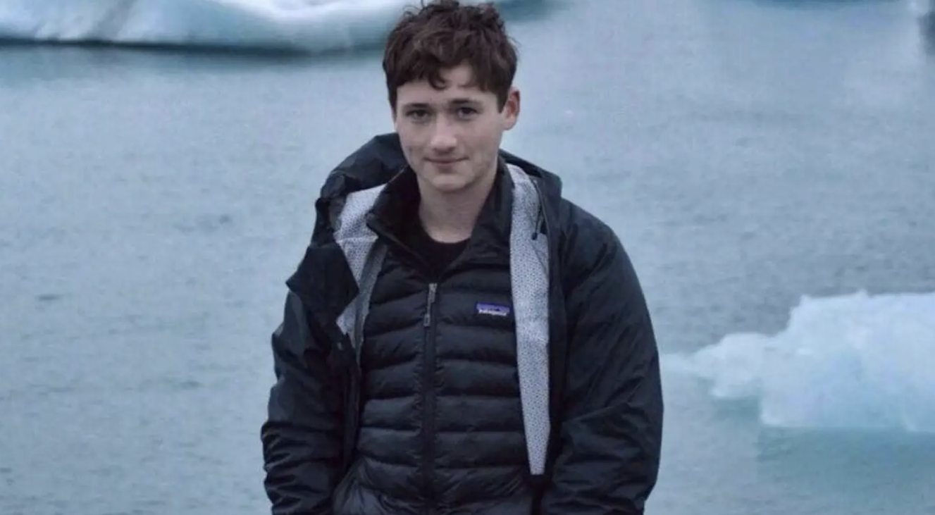 A photo of murdered gay Jewish student Blaze Bernstein pictured standing in front of frozen lake