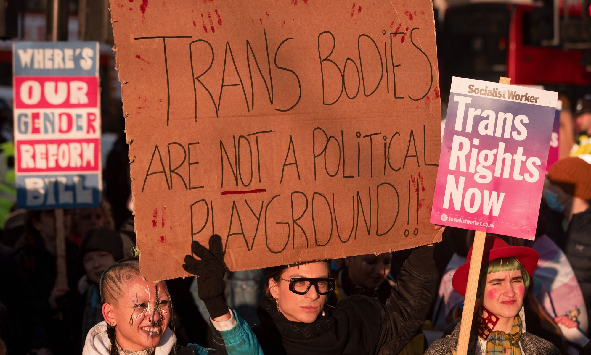 A trans rights supporter holds up a sign reading &quot;Trans bodies are not a political playground&quot; during a protest against the UK Goverment Section 35 stopping Scotland