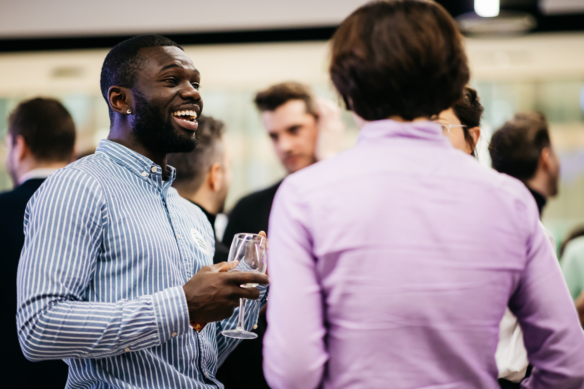 A man holding a glass at a PinkNews Business Community Event