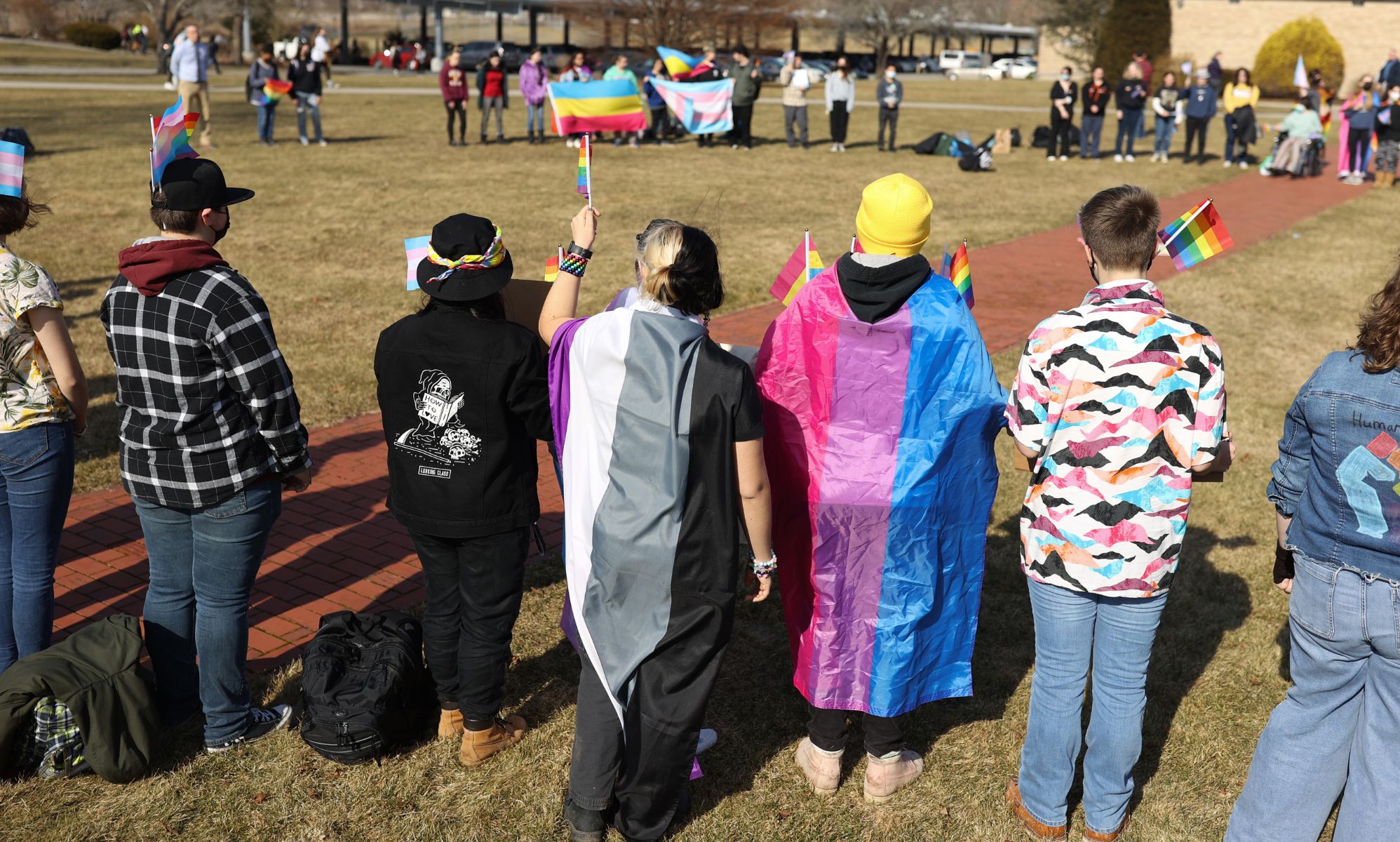High school in Massachusetts wear pride flags and hold up signs in support of the LGBTQ+ community as they walked out in support of a nationwide student protest over Florida