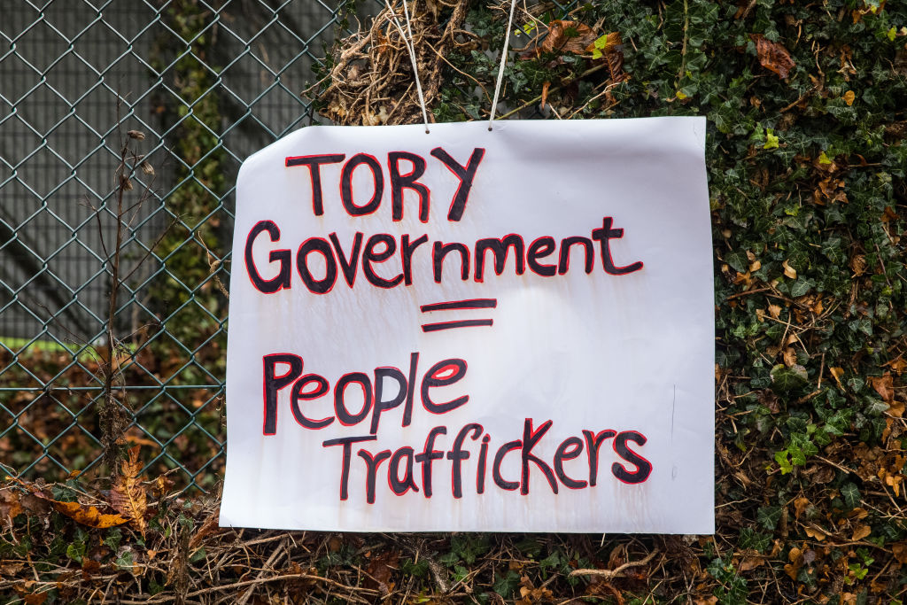 A sign reading &quot;Tory Government = People traffickers&quot; is pictured during a protest outside Manston asylum centre. 
