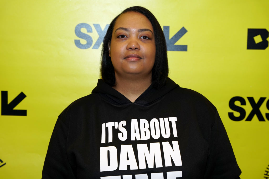 Arlan Hamilton poses for the camera. She is wearing a hooded sweatshirt with the words &quot;It