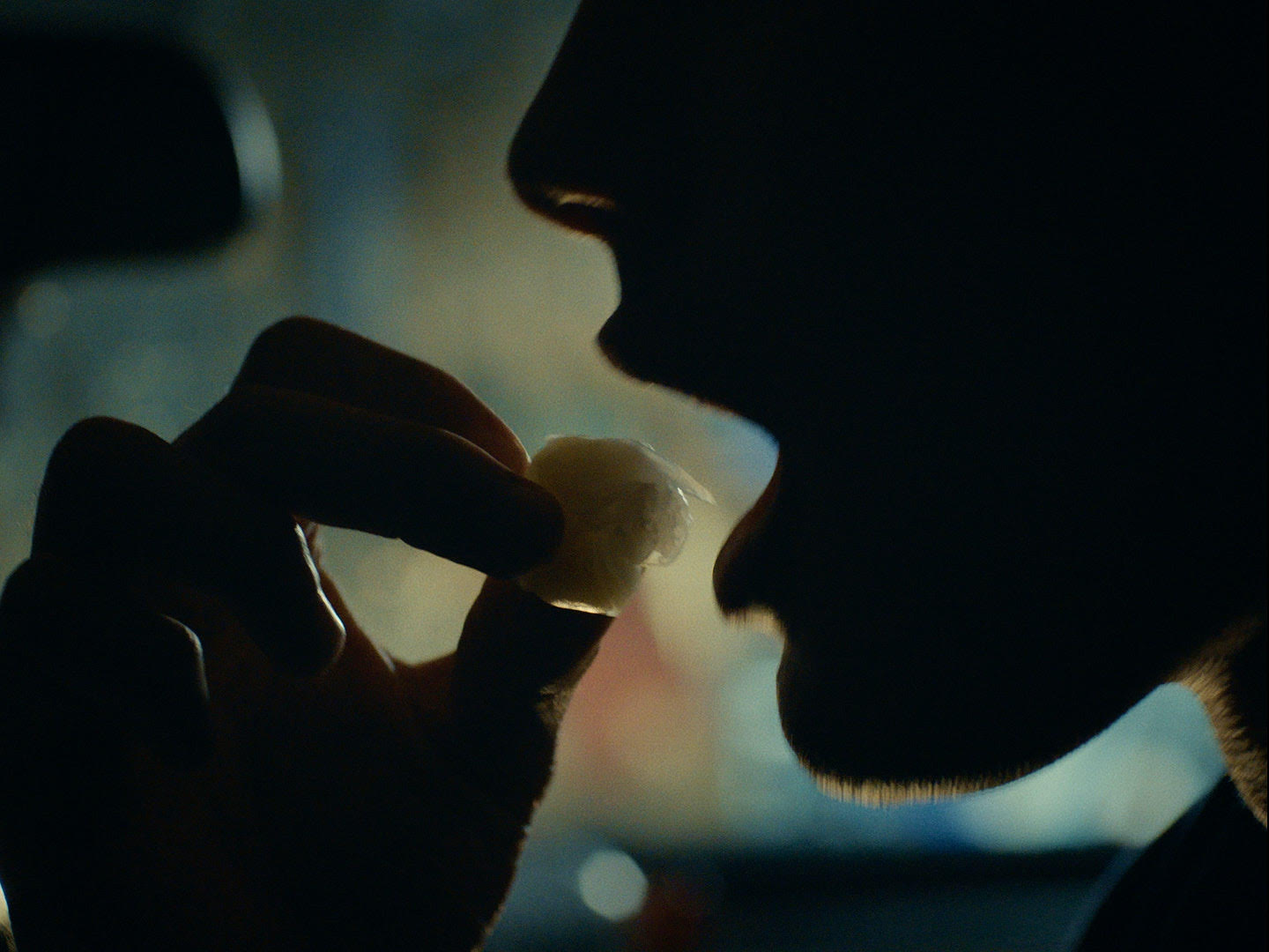 Close up of man putting something into his mouth 