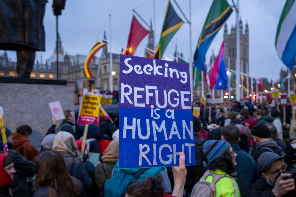 A person holds a sign which says &quot;seeking refuge is a human right&quot; at a pro-refugee rally in London.
