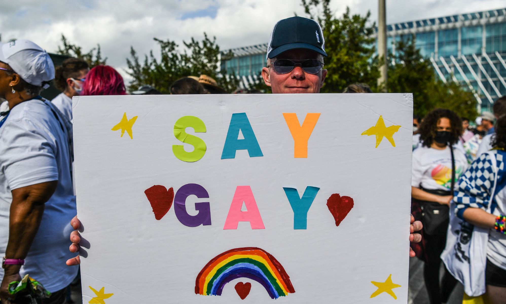 A protester holding a &quot;Say Gay&quot; sign at a protest against Florida