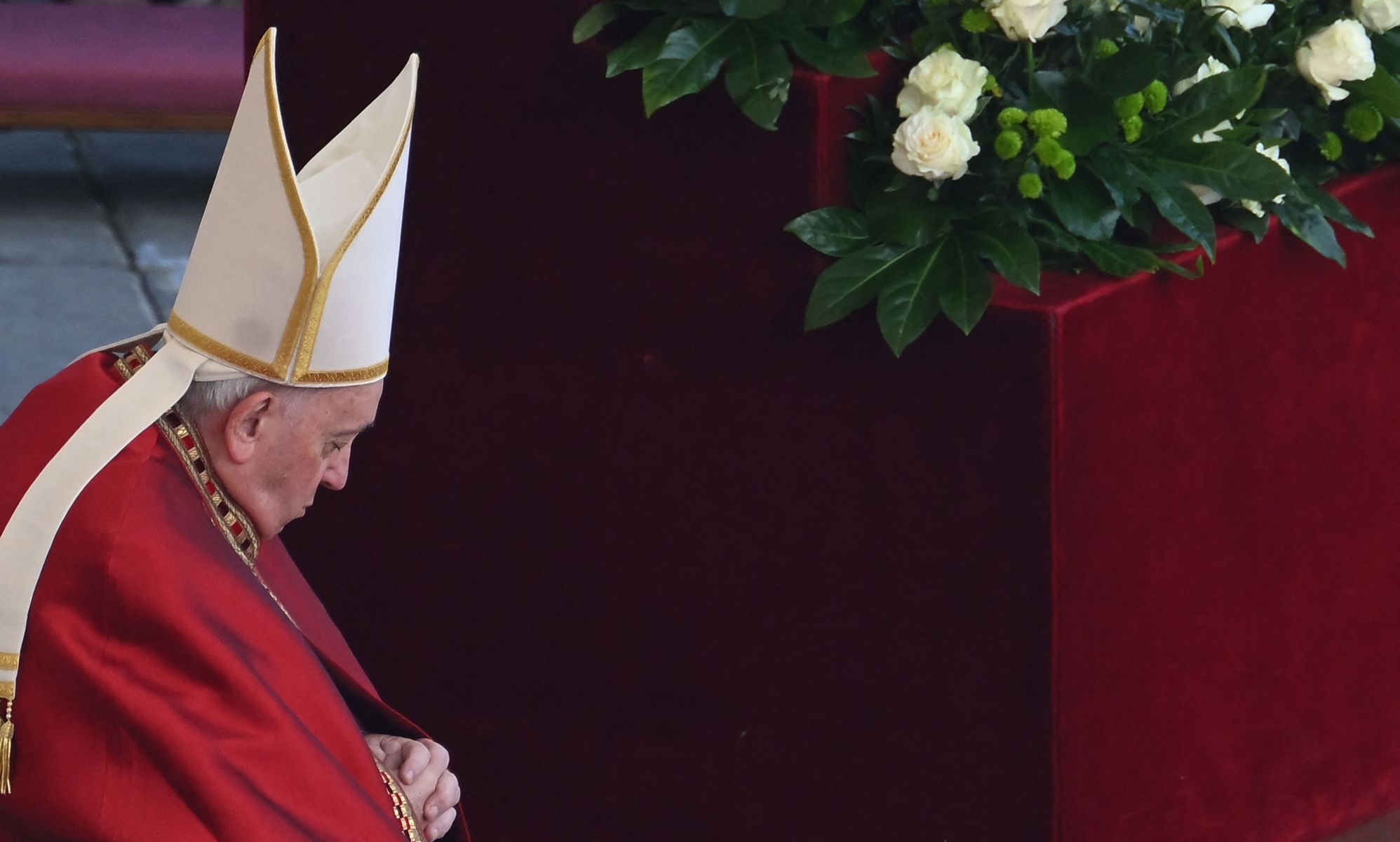 Pope Francis wears red garments and a white cap as he leads the funeral for Pope Benedict, his predecessor