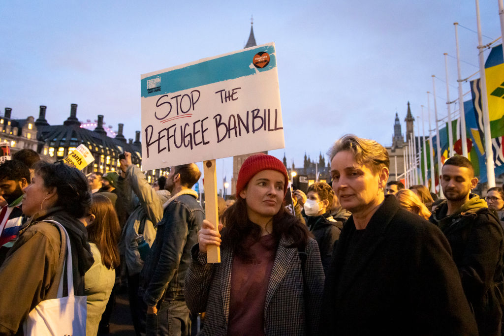 A person holds a sign which says &quot;stop the refugee ban bill&quot; at a protest in London. 