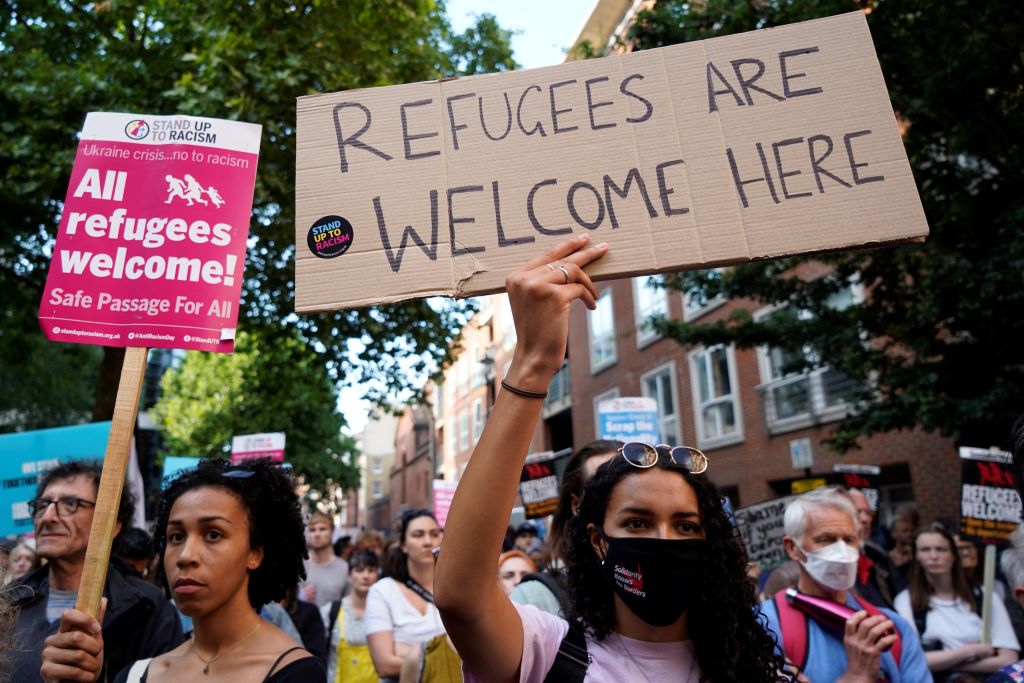Protesters hold placards as they gather outside the Home Office in central London on June 13, 2022. 