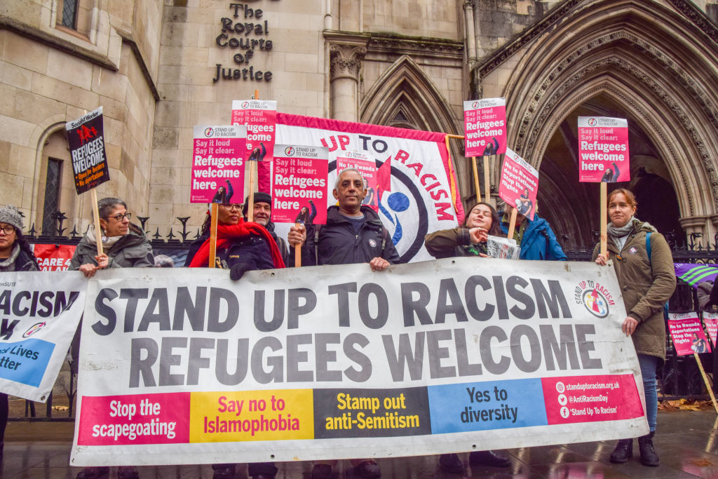 Protesters hold a &quot;Refugees welcome&quot; banner and placards during the demonstration.