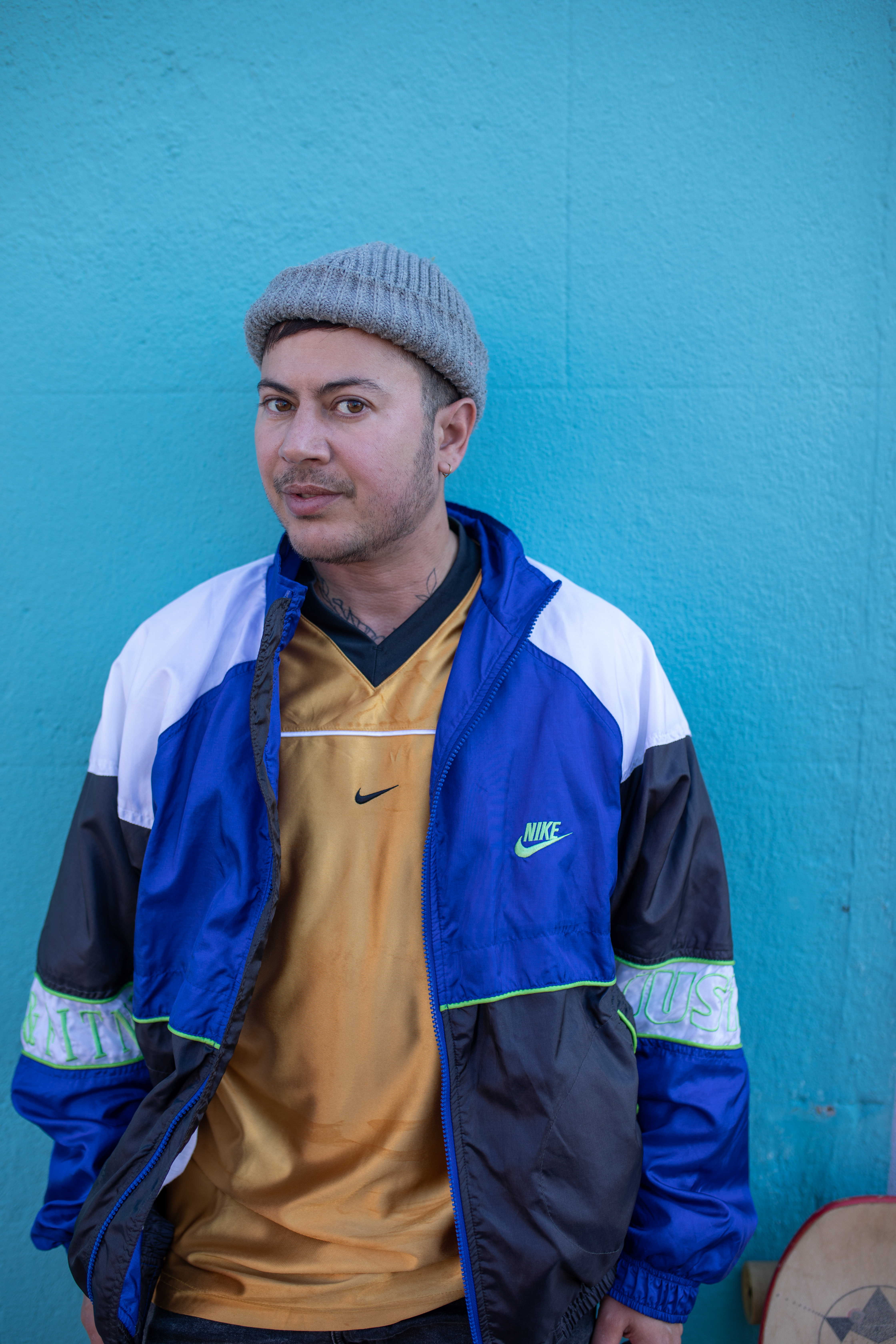 Fox Fisher standing against a blue background.