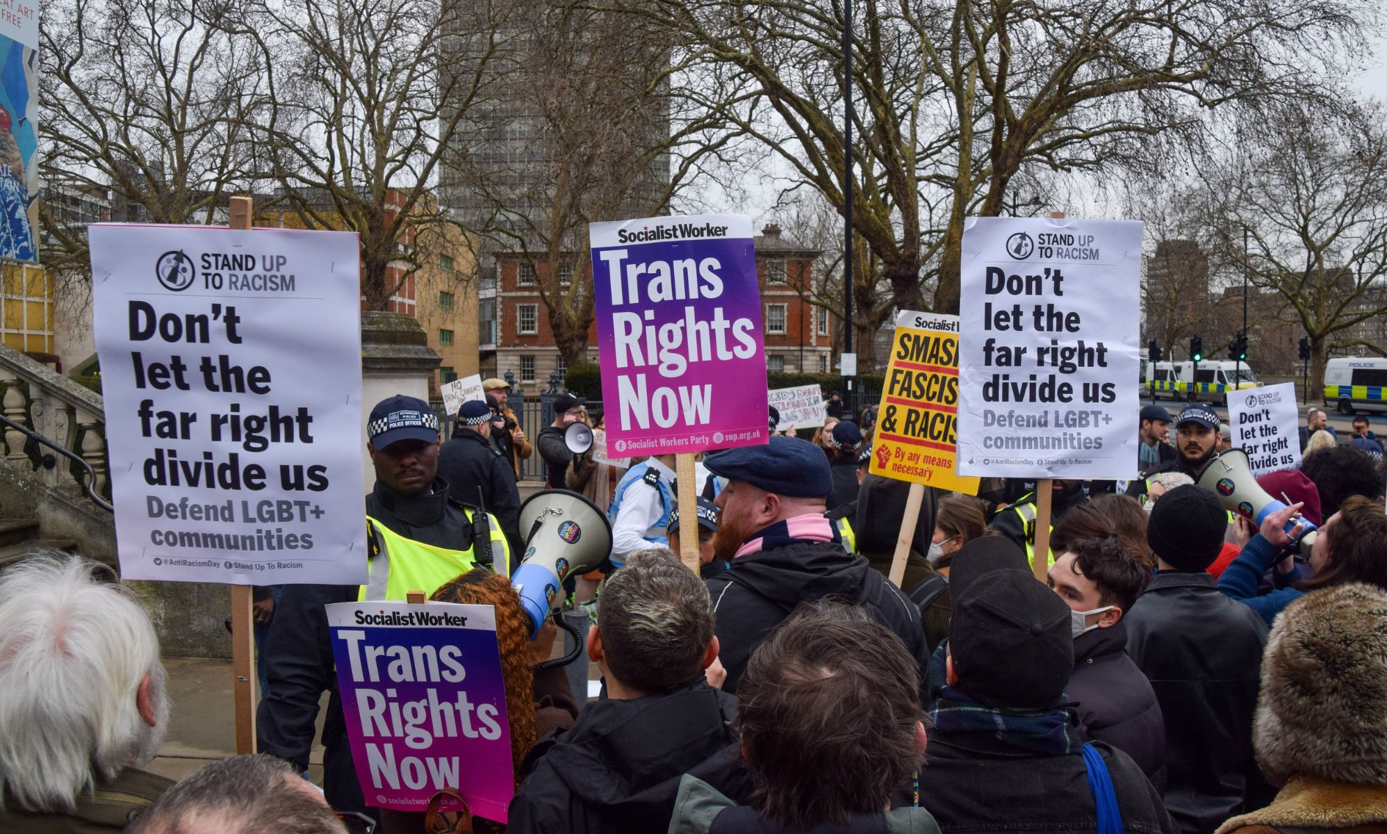 People hold up signs reading 