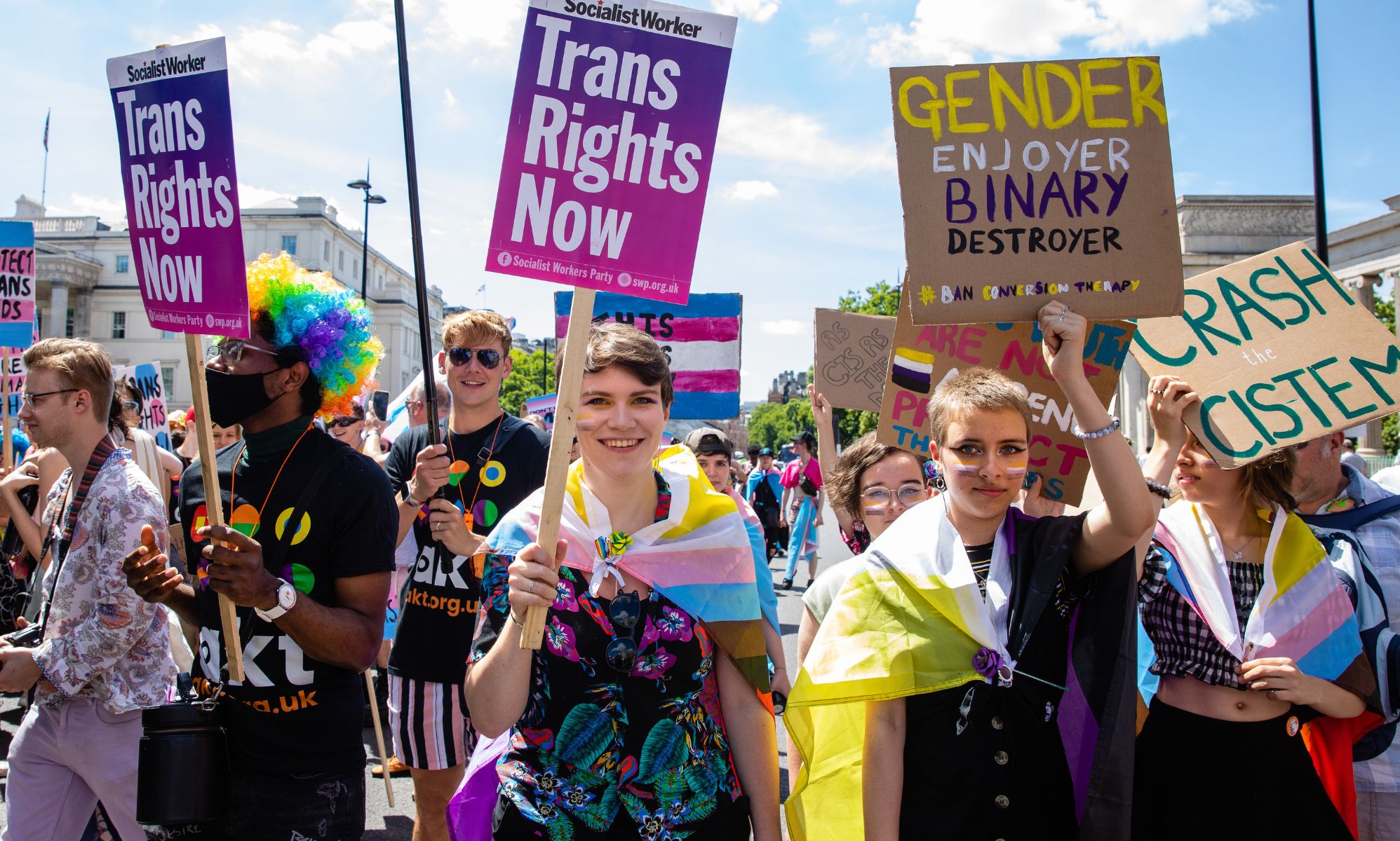 Activists signal their support of transgender rights during London Pride by waving signs reading &quot;trans rights now.&quot;